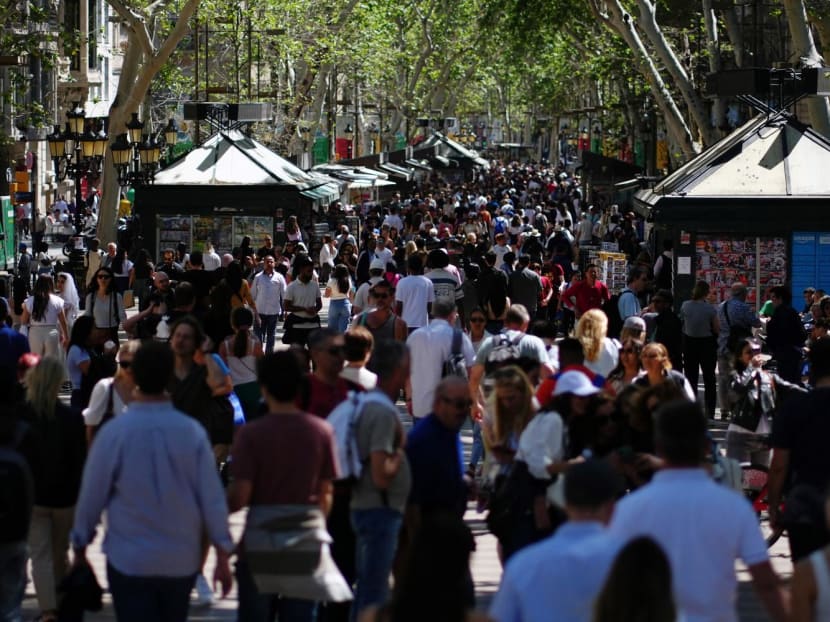 Tourist walk up and down Las Ramblas alley in Barcelona on April 13, 2024. 