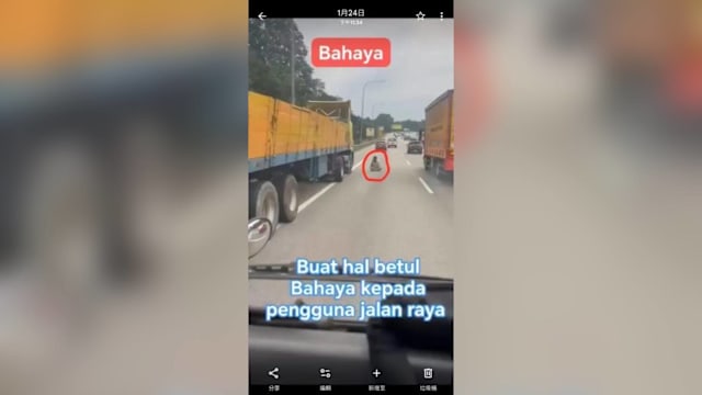 马国男子危坐路中央通电话 途径车辆纷纷闪避