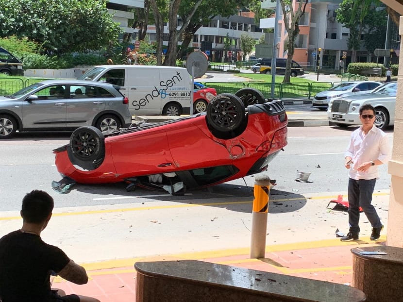 Photos of the incident shared online show a red car overturned on the road, with various pieces of the vehicle scattered nearby.