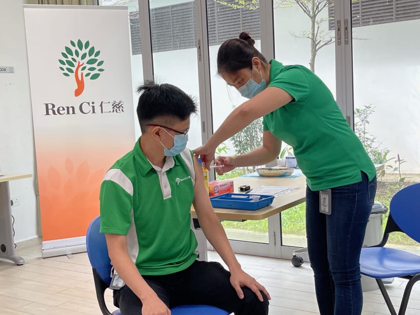 Physiotherapist Dickson Yip (left) was one of 50 staff members at Ren Ci nursing home to get vaccinated on Jan 11, 2021.