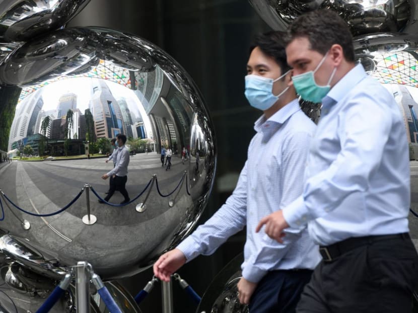 People walking past an art installation in the financial business district of Singapore.