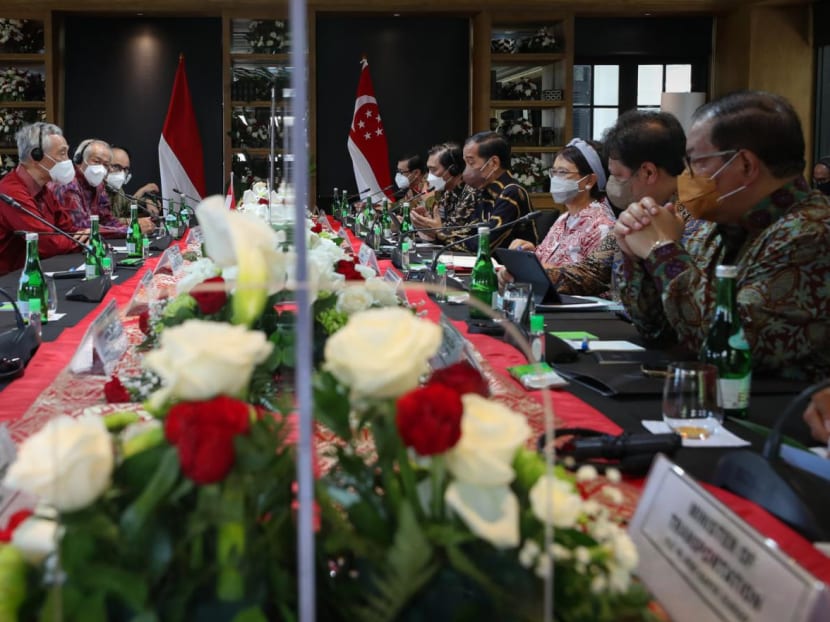 Prime Minister Lee Hsien Loong (centre left) and Indonesia president Joko Widodo, flanked by Cabinet ministers, meet at the fifth Singapore-Indonesia Leader's Retreat on Jan 25, 2022. 
