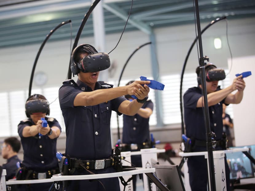 Police officers demonstrate the use of Virtual Reality training equipment during a media preview of the new Mobile Classroom (MobiC), which utilises Virtual Reality (VR) technologies to bring training to the frontline units, on June 12, 2017. Photo: Jason Quah