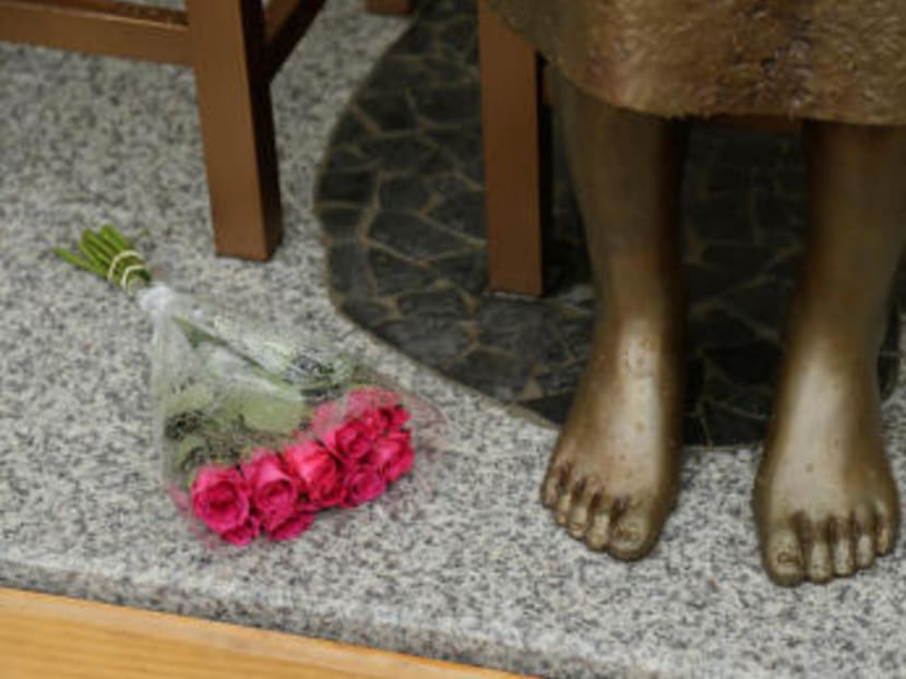 A bouquet lays alongside a statue commemorating Korean "comfort women" at a Sydney church in Sydney. Photo: Reuters