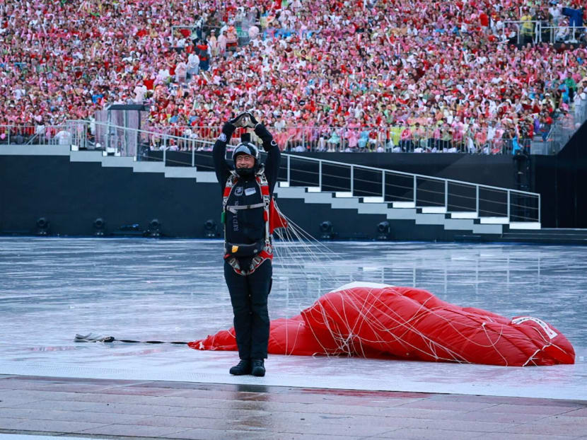 A Red Lion parachutist making a heart sign after his jump at the National Day Parade 2024. A Red Lion parachutist making a heart sign after his jump at the National Day Parade 2024.