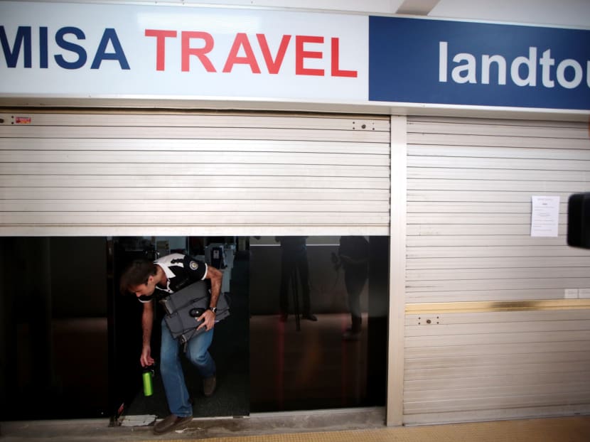 A man, who did not speak to the media, emerges from the shuttered offices of Misa Travel on June 1, 2017. Photo: Jason Quah/TODAY