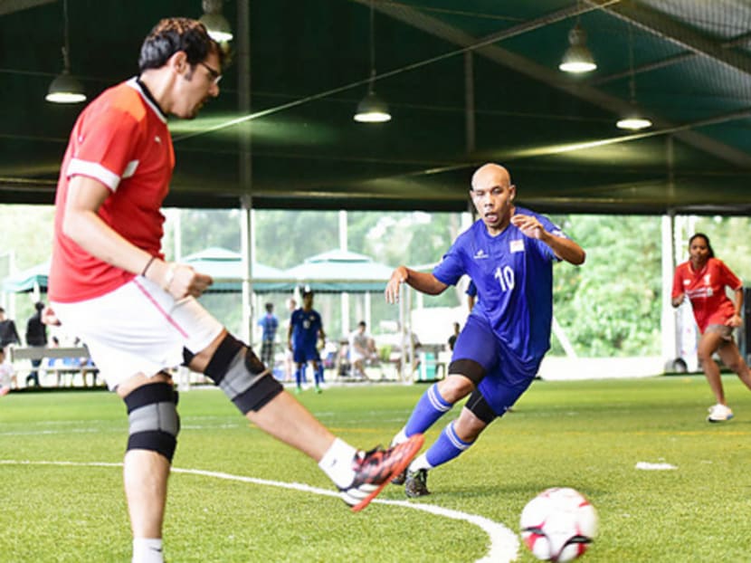 National cerebral palsy footballer Khairul Anwar (in blue) in action in one of the friendly games at a tribute session organised by local fans at the Cage’s Sports Park at Turf City. Photo: Lim Weixiang