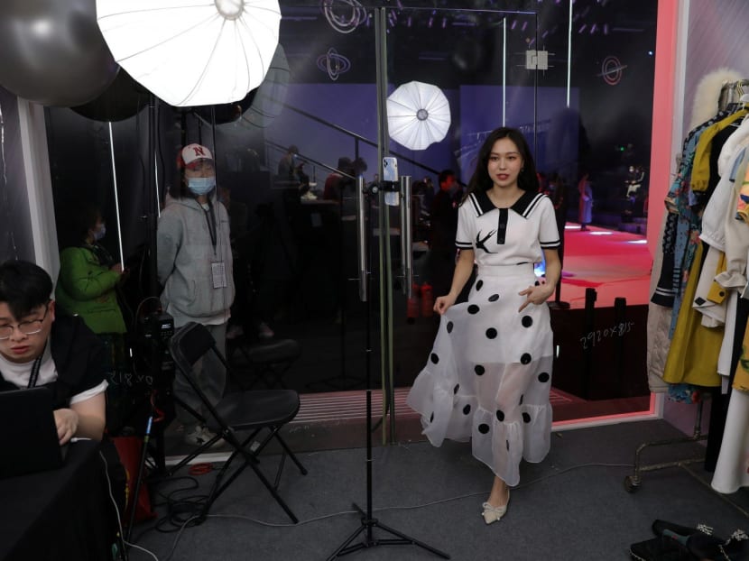 A livestreamer promotes a dress by Xunruo during a live streaming session, inside a booth set up at a show venue during China Fashion Week, in Beijing, China on March 31, 2021.