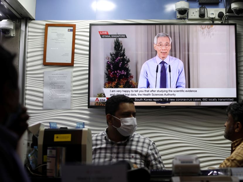 A television screen at a money changer showing PM Lee's live address to the nation on Dec 14, 2020 when he announced that Singapore has approved the Pfizer-BioNTec Covid-19 vaccine for use in Singapore.