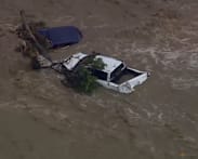 Australia warns of downpours after flash flood swept cars into the sea; bushfires rage in Victoria