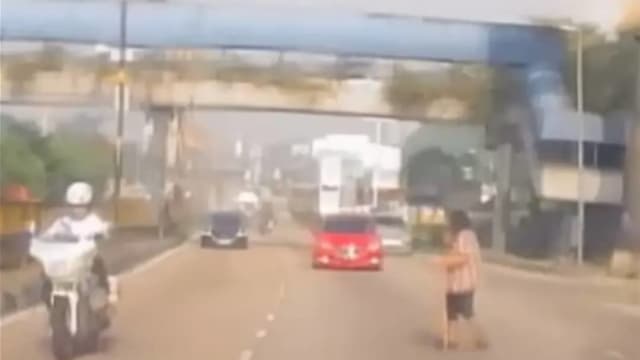 新山老妇乱过马路轿车急刹让行 后方摩托车闪不及撞路旁