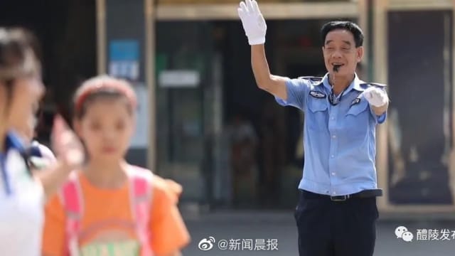 曾目睹两学生被车撞 中国老师化身“交警”16年守护学生