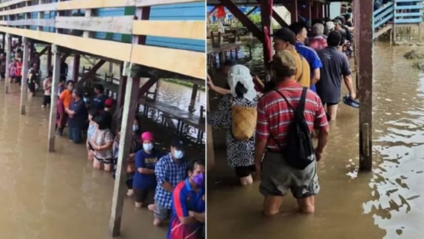 Pengundi di Sarawak beratur dalam air banjir