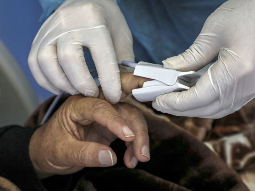 A Covid-19 patient's blood oxygen saturation level being measured with a pulse oximeter in an overseas facility.