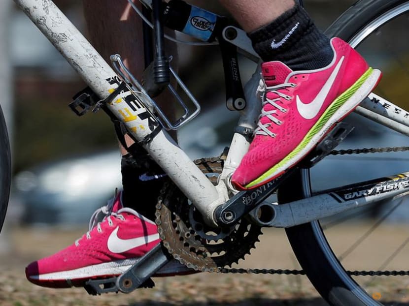 FILE PHOTO: A bicyclist wearing Nike shoes rides along the Charles River in Cambridge, Massachusetts, U.S., March 18, 2019. REUTERS/Brian Snyder/File Photo