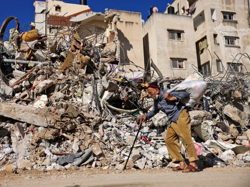 A Palestinian elderly man walks past a building destroyed by Israeli bombardment in Gaza City, on May 19, 2021.