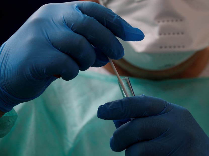 A doctor holds a test tube after administering a nasal swab to a patient at a testing site for Covid-19 in Cambrai, France.