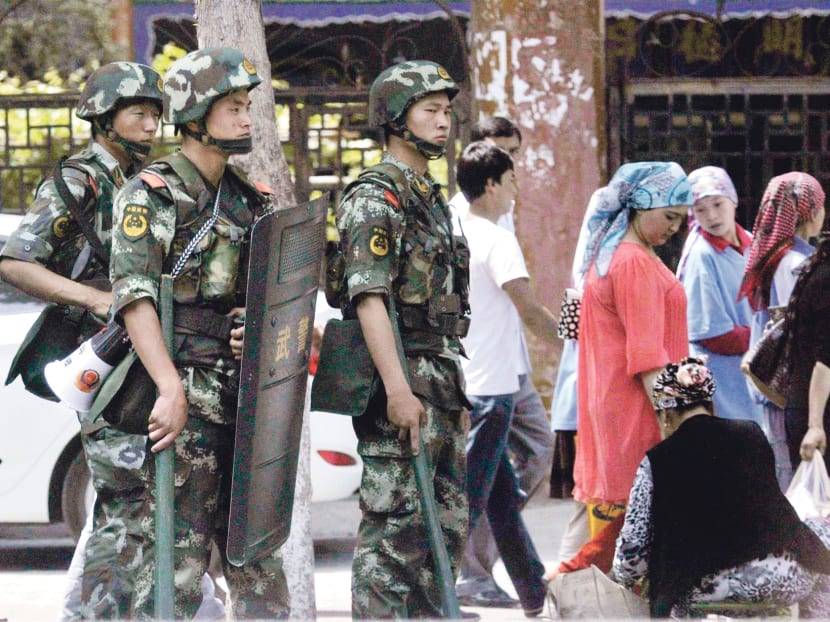 Armed police officers near the grand bazaar in Urumqi. Security services in Xinjiang have stepped up arrests of alleged terrorists, but 
local governments have also experimented with economic incentives to
address resentment. Photo: REUTERS