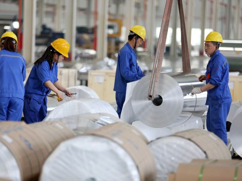 Chinese workers packaging aluminium tapes at an aluminium production plant in Huaibei, China. The United States step up its trade confrontation with China, ordering an investigation into imports of aluminum sheet worth hundreds of millions of dollars a year. Photo: AFP
