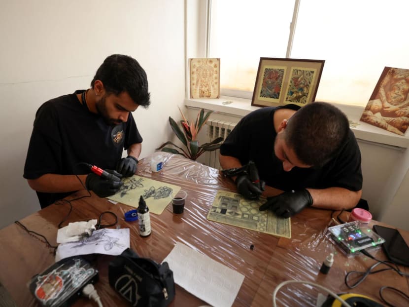 Students training to be tattoo artists practice on a silicon canvases at a studio in Iran's capital Tehran, on Nov 7, 2023.