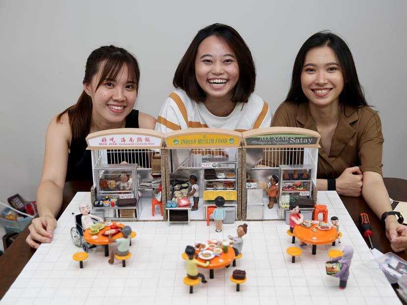 Clay artists (from left) Jocelyn Teo, 31, Oo Xin Man, 23, and Janice Ng, 20, with the miniature model of a hawker centre that they were commissioned to create by the National Heritage Board. Clay artists (from left) Jocelyn Teo, 31, Oo Xin Man, 23, and Janice Ng, 20, with the miniature model of a hawker centre that they were commissioned to create by the National Heritage Board.