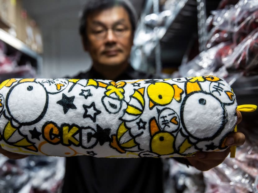 The owner of clothing brand Chickeeduck, Mr Herbert Chow, shows a cushion his company makes decorated with chickens and ducklings in Hong Kong on April 9, 2021.