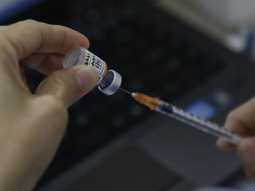 A healthcare worker getting ready a vial of Pfizer-BioNTech Covid-19 vaccine at Our Tampines Hub Vaccination Centre.