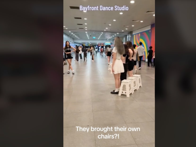 A screenshot from a video showing people practising dance steps within the grounds of an MRT station. A screenshot from a video showing people practising dance steps within the grounds of an MRT station.