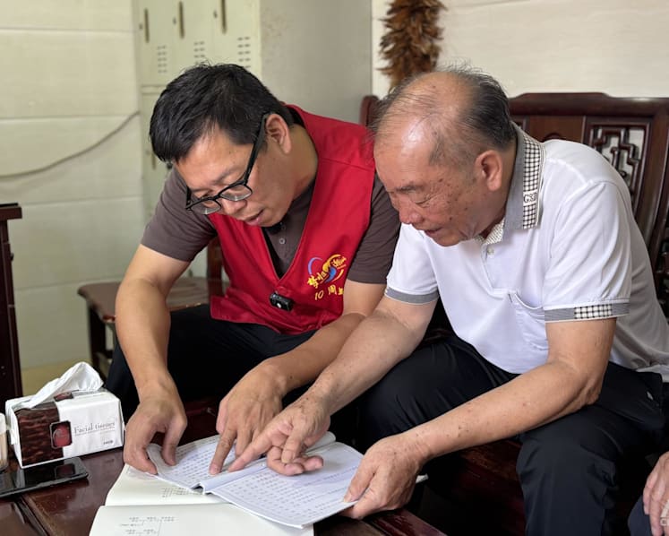 Zeng Jianpeng and clan elder Li Weiming review genealogy records at Li Clan Ancestral Hall in Shantou while verifying clues for a Singaporean’s ancestry search. (Photo: CNA/Melody Chan)