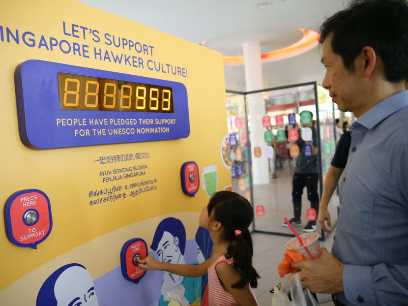 Patrons at a food centre engaging with an interactive board for the Our SG Hawker Culture travelling exhibition in 2018. Patrons at a food centre engaging with an interactive board for the Our SG Hawker Culture travelling exhibition in 2018.