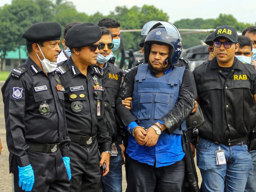 Rapid Action Battalion personnel escort Regent hospital Chairman Mohammad Shahed (centre) allegedly accused of distributing fake Covid-19 coronavirus certificates, following his arrest, in Dhaka on Wednesday, July 15, 2020.