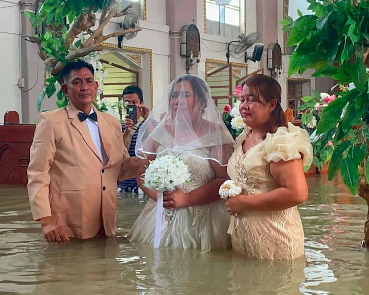 Philippine couple married in hip-deep floodwaters Philippine couple married in hip-deep floodwaters