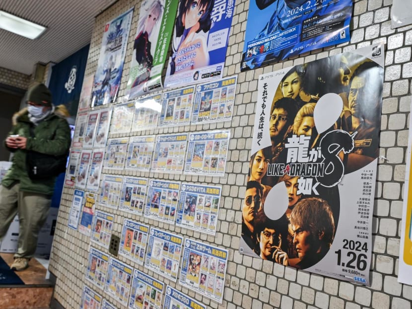 This photo taken on Jan 12, 2024 shows a man walking out of a video game shop displaying a promotional poster for "Like a Dragon: Infinite Wealth", the latest in the Japanese video game franchise "Yakuza" by Sega, in the Akihabara district of Tokyo ahead of the game's release on Jan 26. 