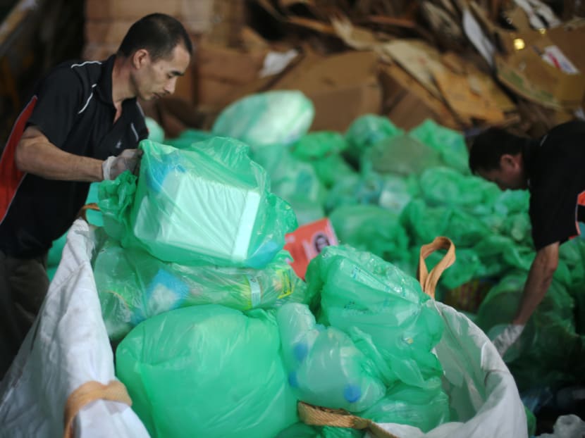 Workers sort through trashed plastic at a recycling plant in Singapore.