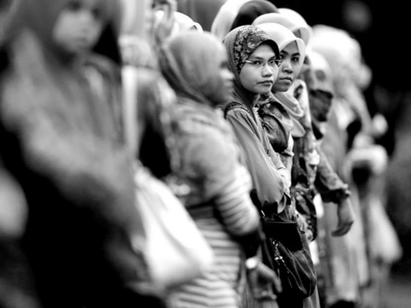 Malaysians of Malay ethnicity waiting to cross a street in Kuala Lumpur. The NEP’s success in creating a powerful bumiputra business and middle class is counterbalanced by its failure to lift their competitiveness correspondingly. Photo: REUTERS