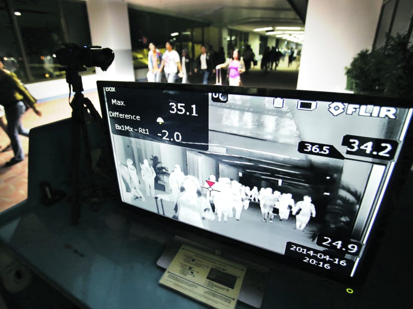 Passengers walking past a thermal scanner at Manila’s International Airport. Philippine officials say a Filipino health worker who tested positive for the Middle East respiratory syndrome coronavirus has arrived home from the United Arab Emirates. Photo: AP