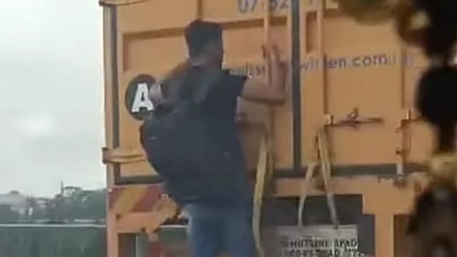 男子紧贴货柜车后搭顺风车 网民：演“不可能的任务”？