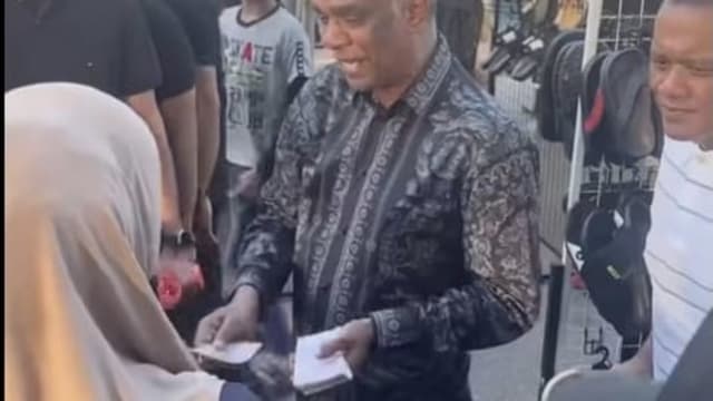 马六甲街头出现 “财神爷” 向他挥手便能领取百元令吉钞票