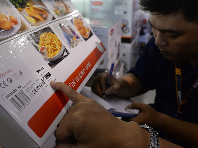 Certis Cisco verifers checking for the presence and authenticity of SPRING Singapore safety labels on consumer electronic products at the Courts Megastore in Tampines. Photo: Robin Choo/TODAY