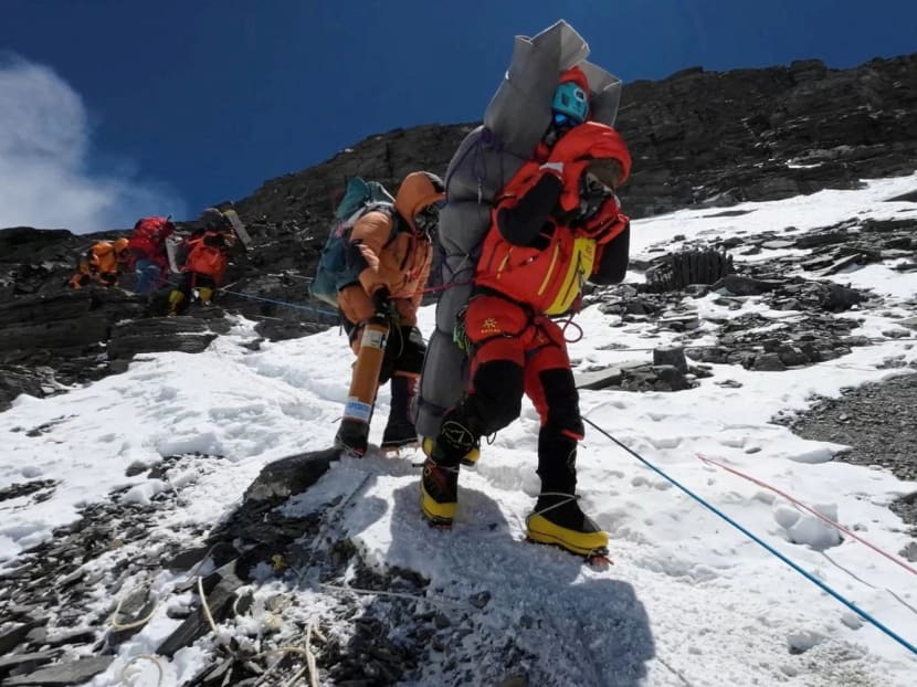 Ngima Tashi Sherpa walking as he carries a Malaysian climber while rescuing him from the death zone above camp four at Everest, Nepal, on May 18, 2023 in this screengrab obtained from a handout video. 