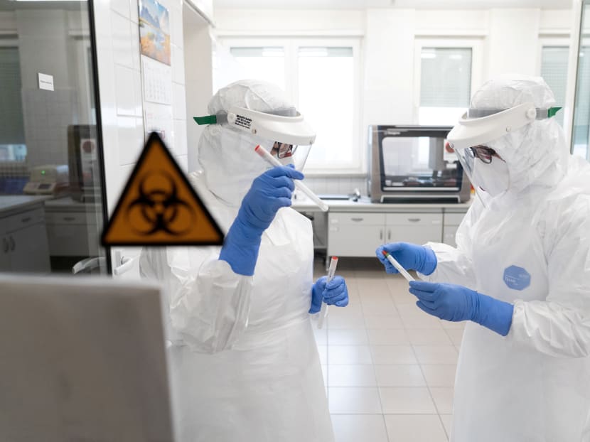 Workers wearing protective suits at a laboratory which performs diagnostic tests for Covid-19 in Olsztyn, Poland, on March 12, 2020. Workers wearing protective suits at a laboratory which performs diagnostic tests for Covid-19 in Olsztyn, Poland, on March 12, 2020.