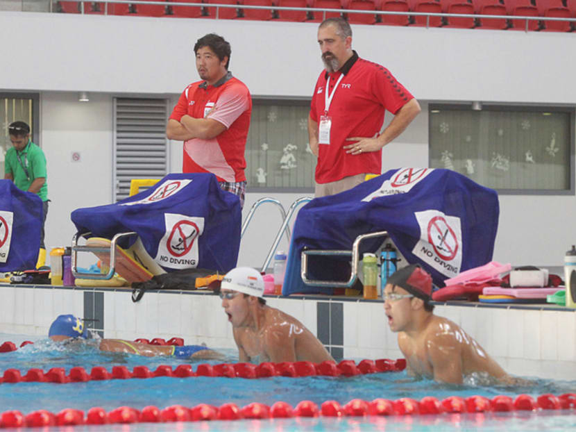 National swimming head coach Sergio Lopez (standing, right) with his assistant Gary Tan at a training session with the national swimmers at the OCBC Aquatic Centre yesterday. Photo: Ooi Boon Keong