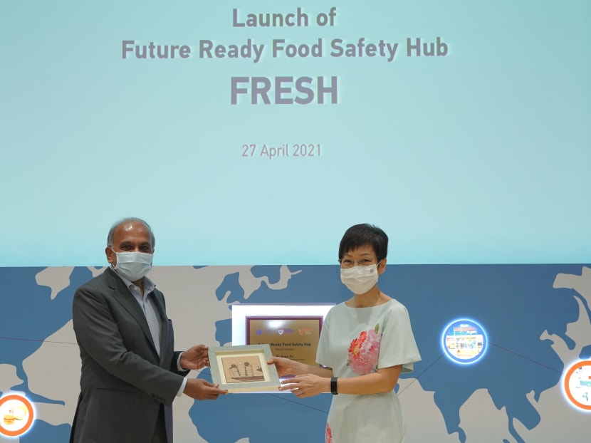 Professor Subra Suresh, president of the Nanyang Technological University, presenting Ms Grace Fu, Minister for Sustainability and the Environment, with a memento — a frame with an artwork depicting The Hive, a building at the university, during the launch of the Fresh platform.