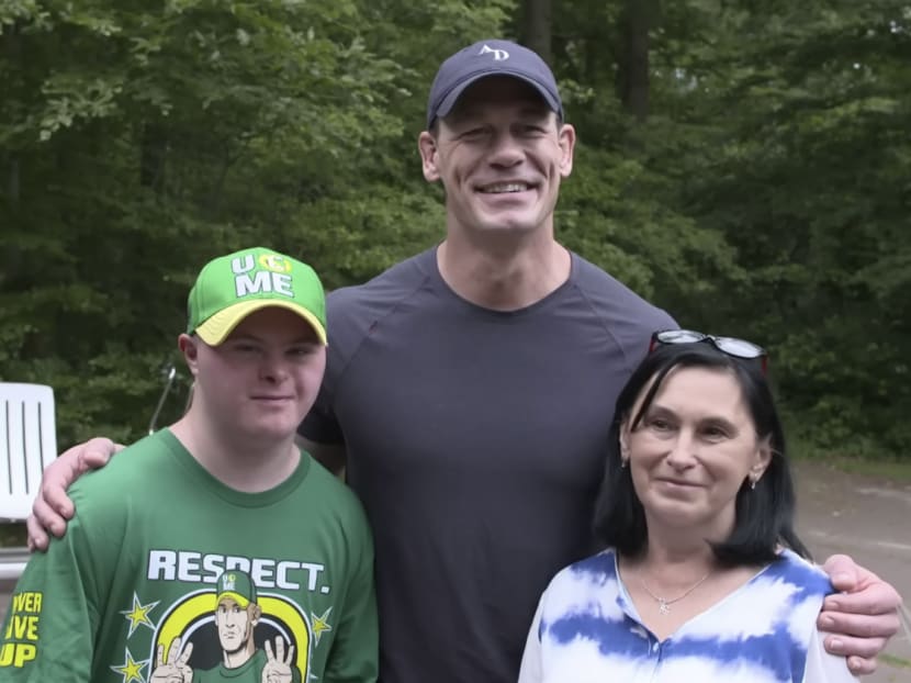 Wrestler and actor John Cena (centre) with 19-year-old Misha Rohozhyn, who has Down syndrome and is unable to speak, and his mother Liana Rohozhyn. Wrestler and actor John Cena (centre) with 19-year-old Misha Rohozhyn, who has Down syndrome and is unable to speak, and his mother Liana Rohozhyn.