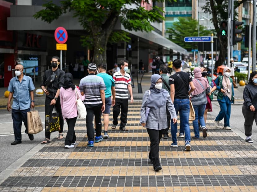 People cross a street in Kuala Lumpur on Oct 8, 2021.