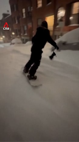 Skier, skateboarder turn snowy Boston roads into playground