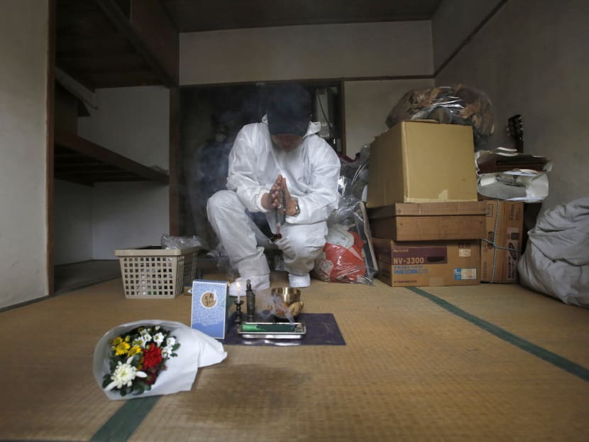 Mr Hirotsugu Masuda, a special cleaning worker prays in front of a stain on the floor in Tokyo where a body of an 85 year-old man was left for over a month. Many elderly Japanese men are now facing the unwitting prospect of growing old alone. Photo: Reuters
