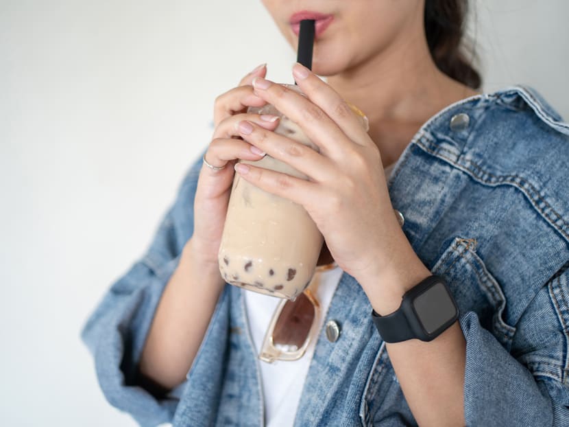 A stock photograph of a woman drinking bubble tea. A stock photograph of a woman drinking bubble tea.