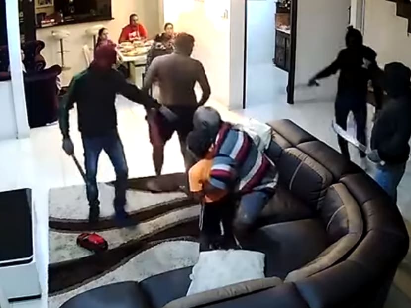 The suspects were seen herding their victims into a room before they allegedly plundered the house. They got away with a total of S$9,950, police said.