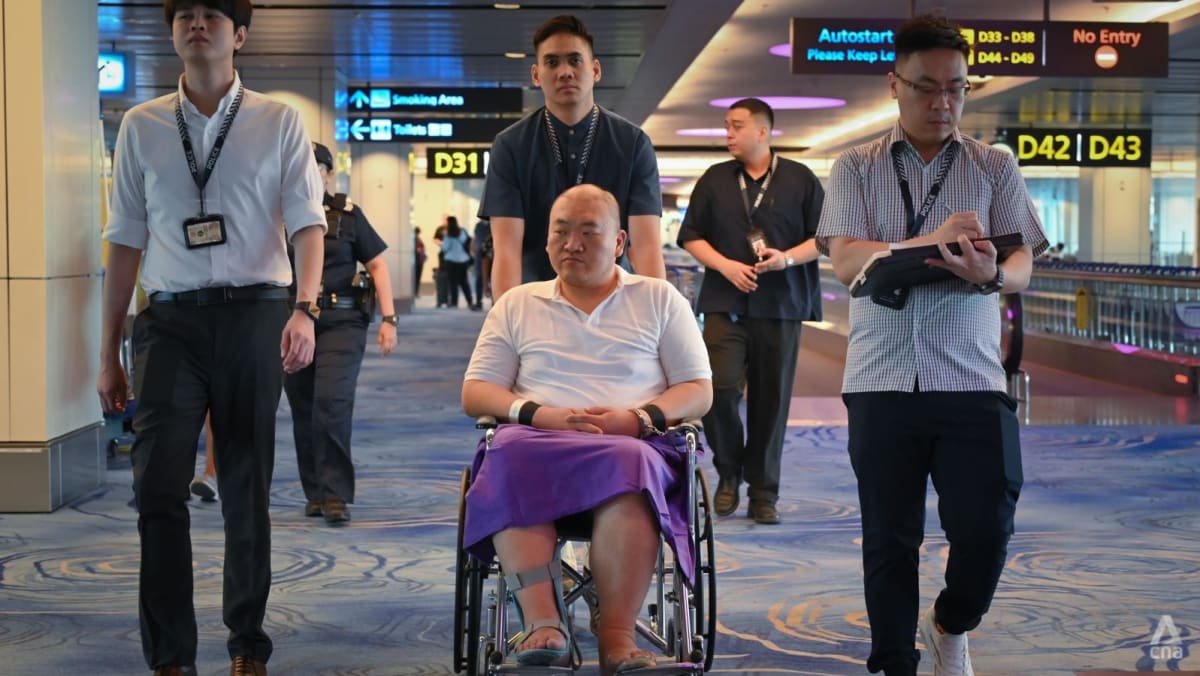 Two men charged with inflight theft taken back to crime scene at Changi Airport